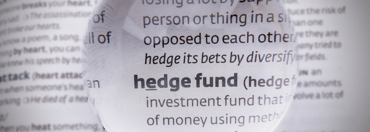 Hedge fund definition in a dictionary under a magnifying glass. 