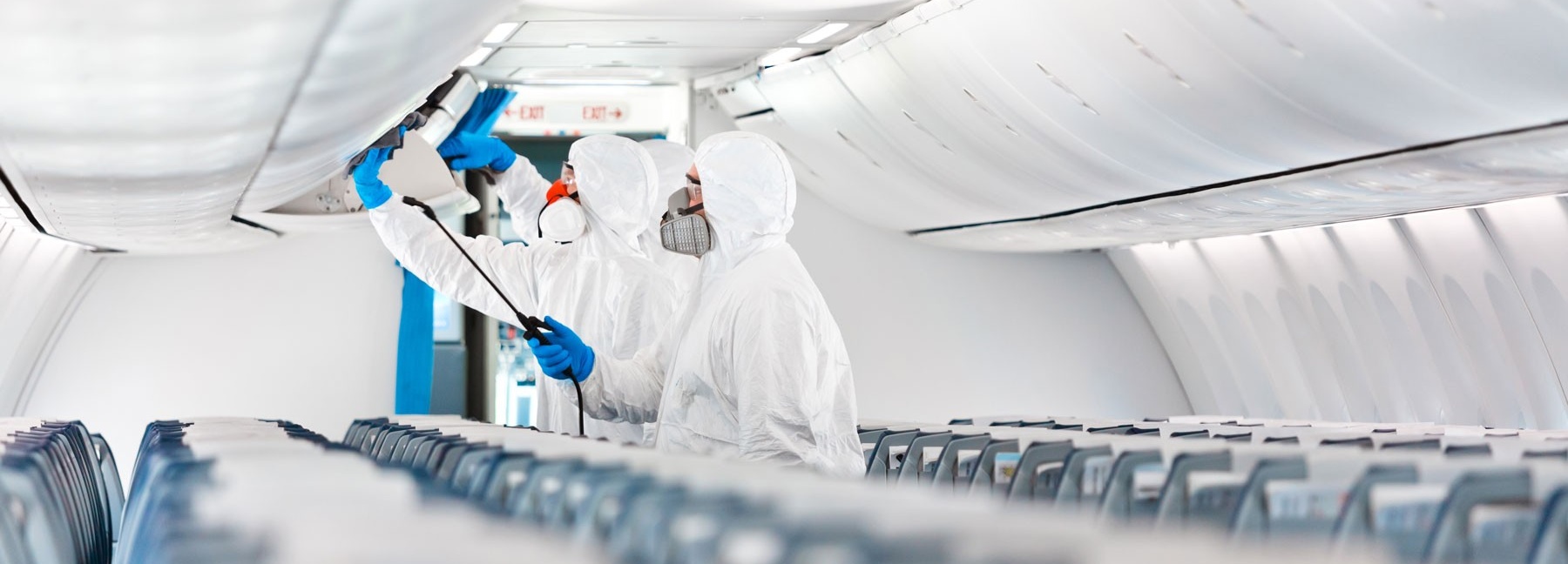 Workers clean and disinfect an empty airplane. 
