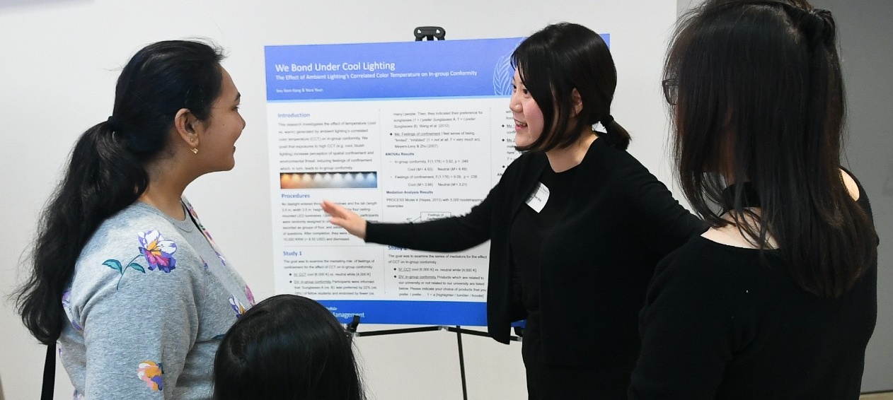 PhD in Management student discussing her research at the PhD Showcase poster presentation. 