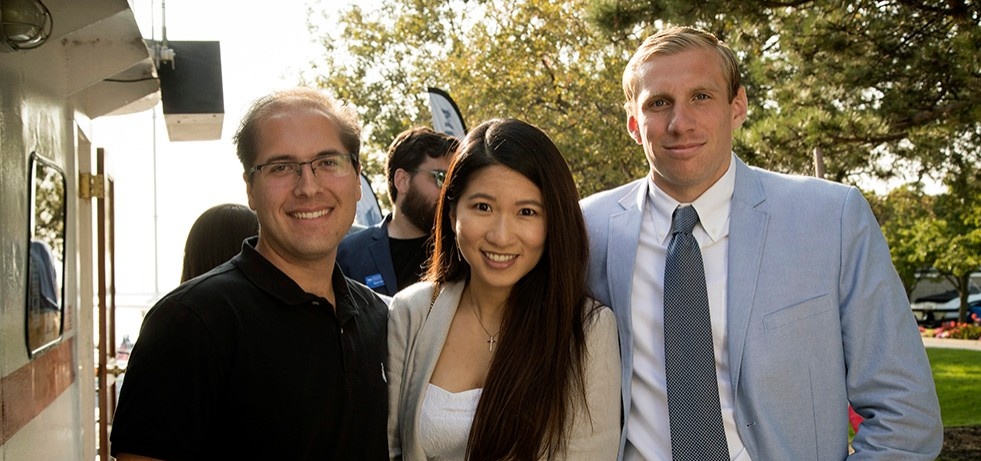 Three MBA students at an Advantage event. 